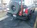 1992 Ford Bronco - Rear view of a brown 1992 Ford Bronco equipped with a spare tire, jack, and chains.