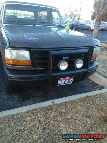 Front view of a 1992 Ford Bronco with a bull bar and two fog lights. License plate reads 1A GUGGG