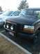 1992 Ford Bronco - A 1992 Ford Bronco is parked in a lot, showing its front grille and bumper with added lights.