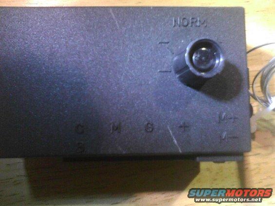Black electronic box with a dial labeled NORM and markings for C, M, G, +, M+, M-
