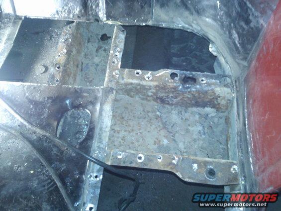 rusted metal floor pan with holes and some welding