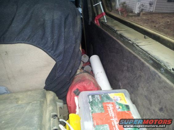 Interior cargo area with a red bag, white pipe, and a first aid kit