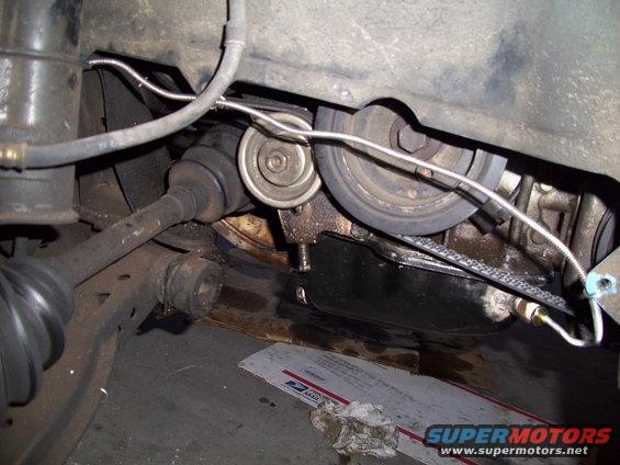 Engine oil pan and drive axle with pulley system. Some oil leaks visible