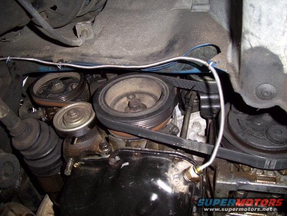 Engine belt and pulleys with visible text 'SUPERMOTORS.NET'