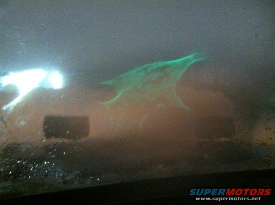 Glowing green abstract shape with bright white light on the left