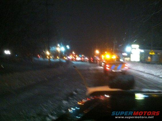 Traffic jam at night with snow on the ground and flashing lights from emergency vehicles