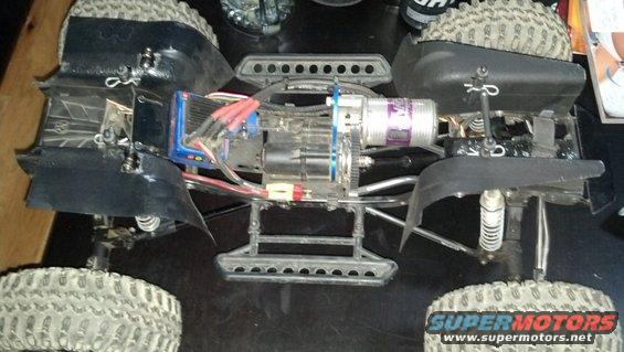 RC car chassis with motor, electronics, and suspension visible