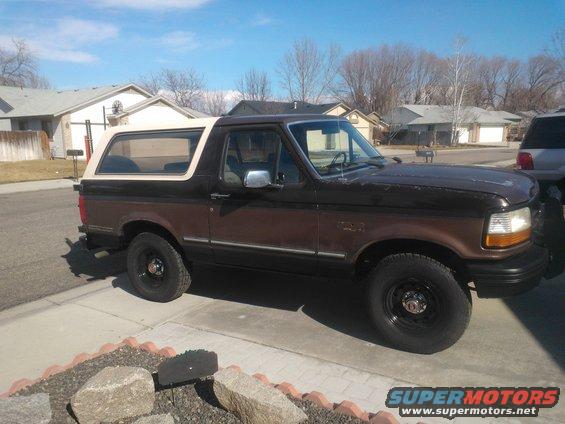 Brown Ford Bronco with a white top parked in a driveway