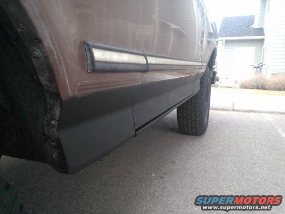 Side view of brown SUV with black trim and white stripe