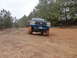 1990 Ford Bronco - A Ford F-Series truck navigates a muddy path with snow falling.