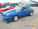 2003 Ford Crown Victoria - A blue Ford Mustang hatchback is parked at a drag strip with other vehicles visible.