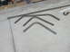 1990 Ford Bronco - Several bent metal tubes and a hook lie on a concrete surface, possibly for a custom build.
