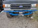 1990 Ford Bronco - Front view of a 1990 Ford Bronco a custom blue front bumper with an integrated winch.