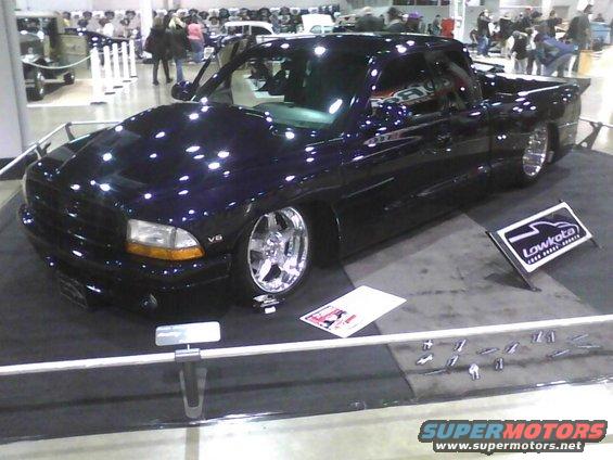 Dark purple pickup truck with chrome wheels, lowered suspension, on display