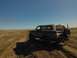 1992 Ford Bronco - Ford Bronco navigates a dusty off-road path under a clear blue sky.