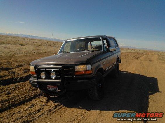 Brown 1992 Ford Bronco on a dirt road in a dry, open landscape