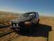 1992 Ford Bronco - This 1992 Ford Bronco is parked on a dirt track in a desert-like environment under a clear blue sky.