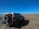 1992 Ford Bronco - A Ford Bronco navigates a dusty, off-road trail under a clear blue sky.
