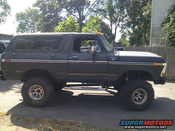 Dark gray Ford Bronco lifted with aftermarket wheels and side steps