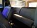 1979 Ford Bronco - The interior of a vehicle, unique purple seat inserts and a gray bench seat, is illuminated by sunlight.