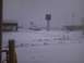 2003 Ford Crown Victoria - A snowy scene at a car dealership, with multiple vehicles visible in the lot.