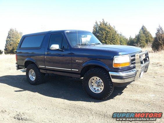 Blue 1995 Ford Bronco with aftermarket bull bar parked on dirt road