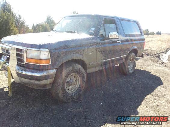 Dark blue 1995 Ford Bronco parked on muddy ground