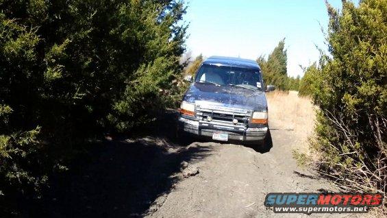 1995 Ford Bronco on a dirt path, front view. License plate reads 'YFT 7899'