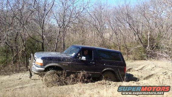 Dark blue 1995 Ford Bronco stuck in mud off-road