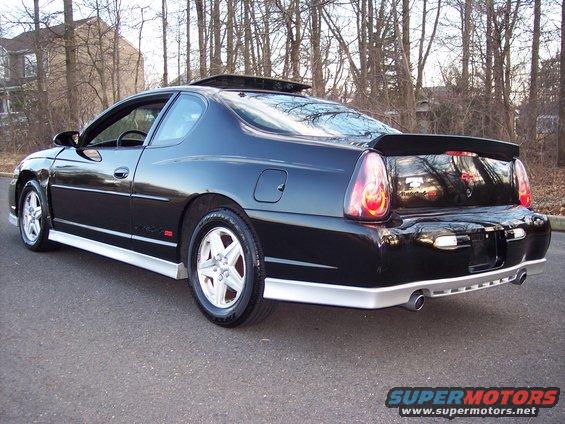 Black Chevrolet Monte Carlo with a rear spoiler and silver trim, viewed from the rear three-quarter angle