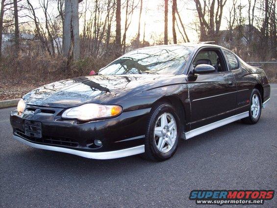 Black 2002 Chevrolet Monte Carlo parked on asphalt with trees in the background