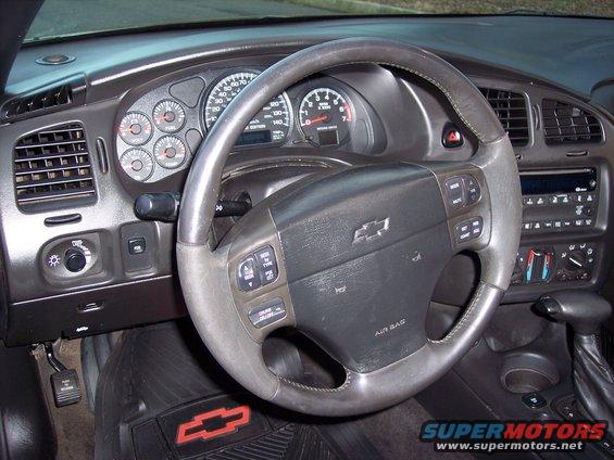 Interior shot of a Chevrolet Monte Carlo, showing the steering wheel, dashboard gauges, and center console