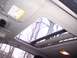 2002 Chevrolet Monte Carlo - View from inside a car's cabin looking up at an open sunroof with trees visible outside.