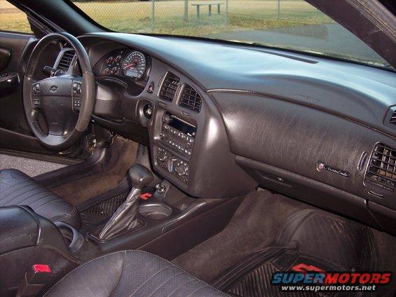Interior view of a Chevrolet Monte Carlo showing the dashboard, steering wheel, center console, and seats. A badge on the dash reads 'Monte Carlo'