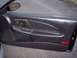 2002 Chevrolet Monte Carlo - The interior door panel of a car shows wear and tear on the dark plastic surface.