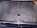 2002 Chevrolet Monte Carlo - The carpeted interior of a car's trunk shows some stains and a central circular emblem.