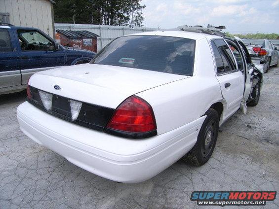 White 2003 Ford Crown Victoria, rear view, damaged driver's side door and fender