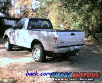 Rear 3/4 view of a 1997-2003 Ford F-150 pickup truck parked on a dirt road