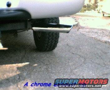 Close-up of a truck's chrome exhaust pipe and tire