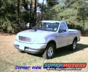 Silver 2000 Ford F-150 regular cab pickup truck parked on grass with trees in background
