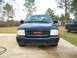 2000 GMC Sonoma - A blue 2000 GMC Sonoma pickup truck is shown from the front, with another truck in the background.