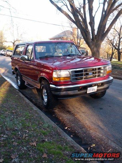 Red 1995 Ford Bronco parked curbside, front quarter view