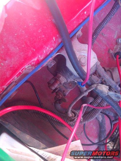 Close-up of red engine bay with various wires and electrical connections