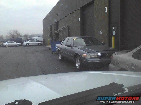 Gray 2003 Ford Crown Victoria with yellow 59 tag on windshield, parked outside