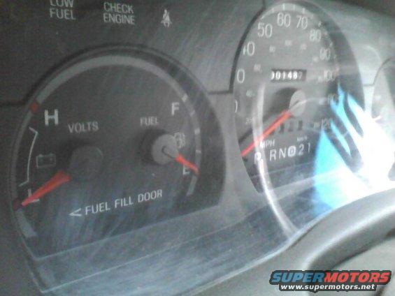 Dashboard with fuel and volt gauges, speedometer reads 0 mph, odometer shows 001487
