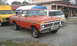 1987 Ford Bronco - A vintage Ford pickup truck is parked outside a building with other vehicles.