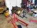 1979 Ford F-150 - Engine block on a stand in a garage setting, with a Schaeffer's oil drum nearby.