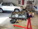 1979 Ford F-150 - Engine block on a stand in a garage with a silver SUV parked behind it.