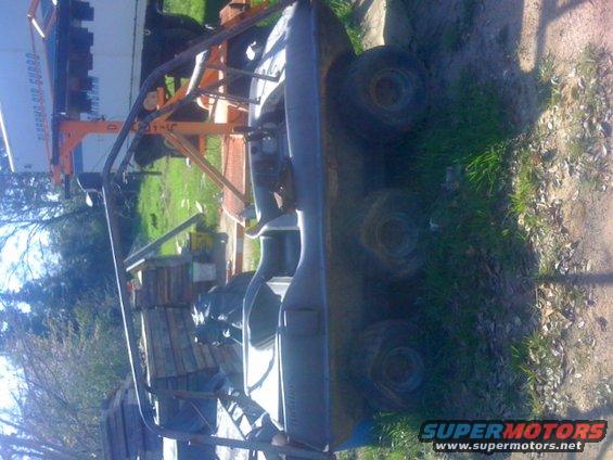 Off-road vehicle frame with roll cage and four wheels visible