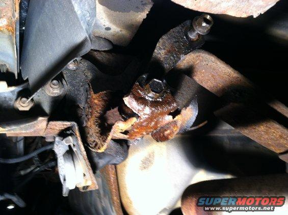Heavily rusted metal bracket and bolt assembly on vehicle undercarriage